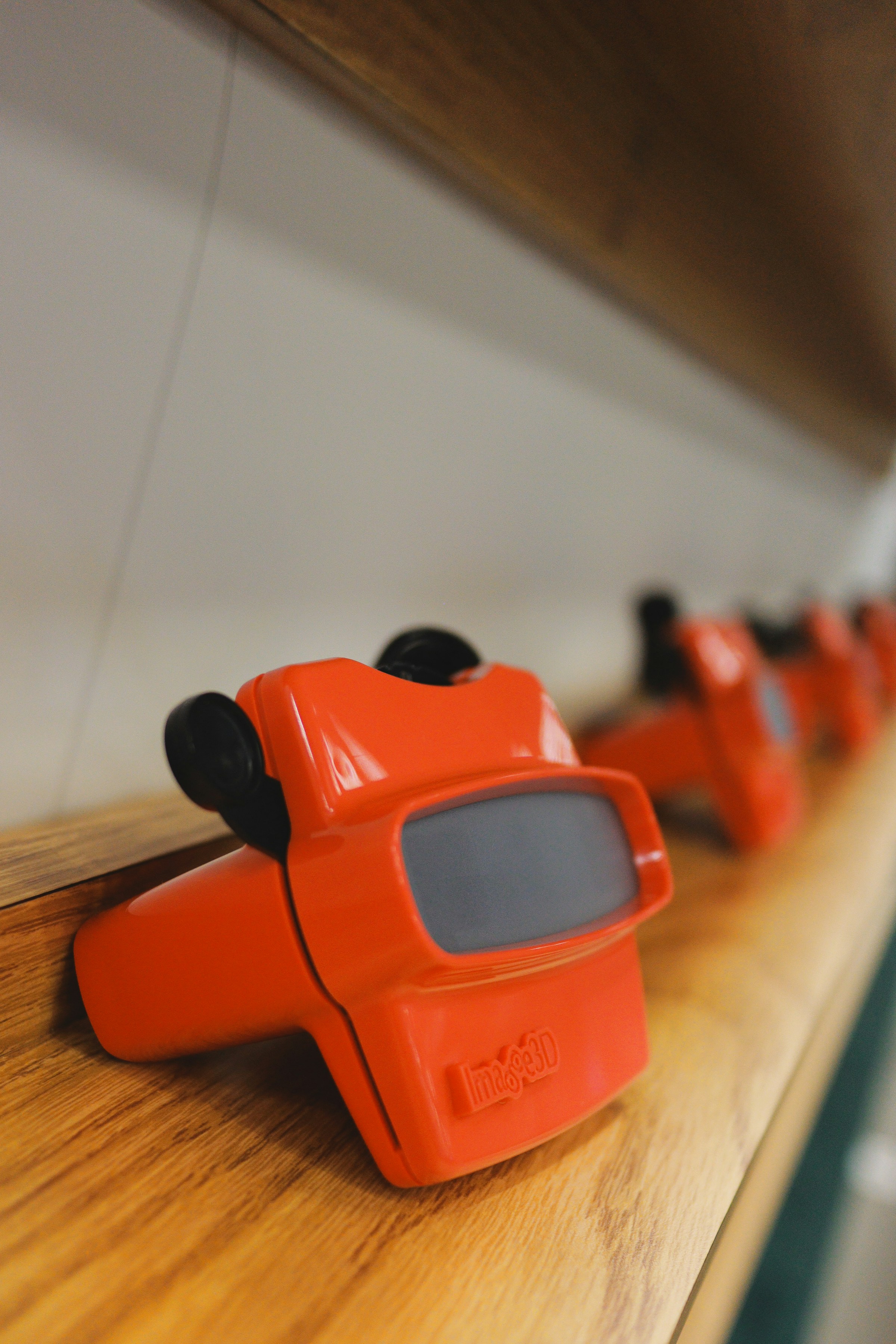 A row of vintage View-Master toys on a wooden shelf